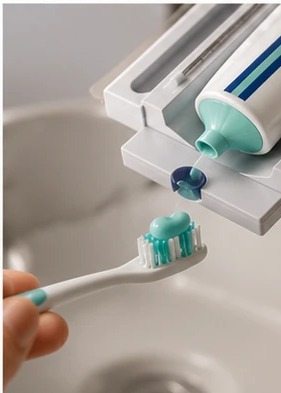 Pearl placing a clean line of toothpaste onto a toothbrush at the sink, no squeezing